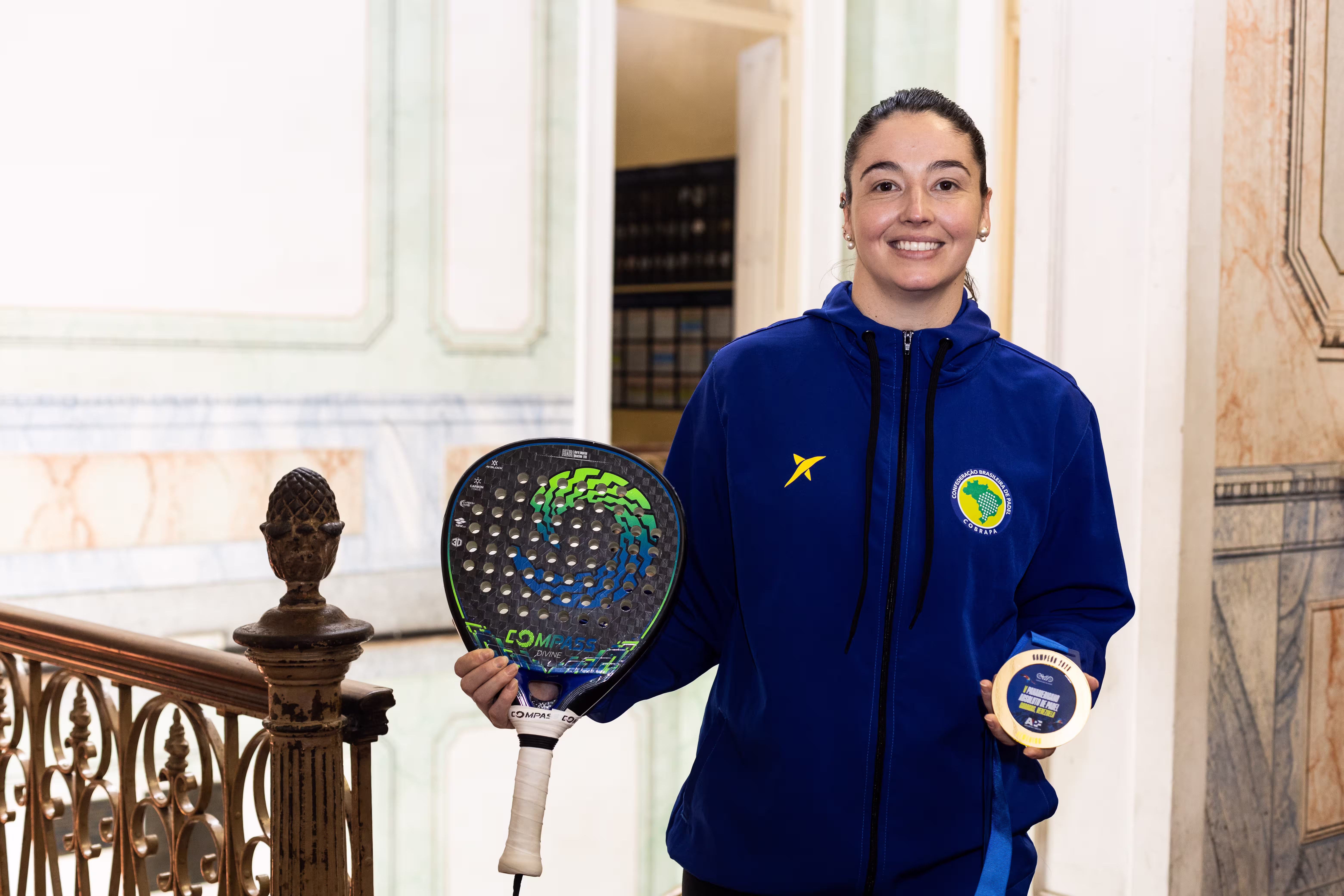 Jugador de pádel sosteniendo una medalla y una pala